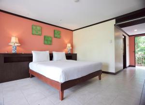 a bedroom with a large bed with an orange wall at Pinnacle Samui Resort in Mae Nam