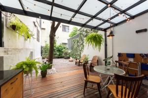 a patio with a table and chairs on a wooden deck at Tree House in Tainan
