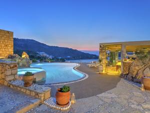 a swimming pool with a view of the ocean at Eirini Luxury Hotel Villas in Grikos