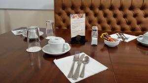 a wooden table with silver utensils on top of it at Royal Swan, Ashley Manor - Bed and Breakfast in Shedfield
