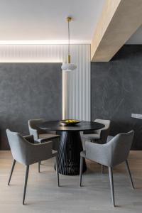 une salle à manger avec une table et des chaises noires dans l'établissement Urbanstay Suites - Prime Location Designer Suite, à Bucarest 30 autres photos