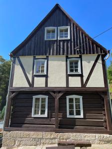 uma grande casa de madeira com janelas brancas em LIETHE 13 - Ferienhaus am Malerweg em Kurort Gohrisch