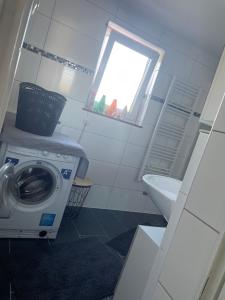 ein Badezimmer mit einer Waschmaschine und einem Waschbecken in der Unterkunft Ferien - Wohnung In Kassel Waldau Zentral in Kassel