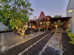 a courtyard of a house with trees and chairs at Omah Nayan in Yogyakarta