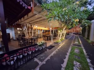 un patio con mesa, sillas y árboles en Omah Nayan en Yogyakarta