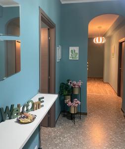 Un pasillo con paredes azules y un mostrador blanco con flores. en Interno1 Bari Policlinico, en Bari
