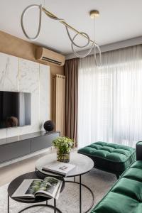 a living room with a green couch and a table at Urbanstay Suites - Prime Location Designer Suite in Bucharest