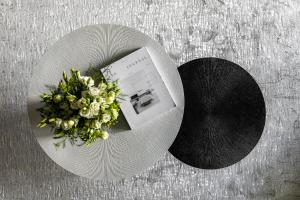 a white plate with a bouquet of flowers on a table at Urbanstay Suites - Prime Location Designer Suite in Bucharest