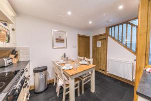 cocina con mesa de madera y sillas en una habitación en Sun Cottage with stunning lake views, Coniston en Coniston