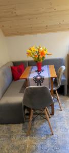 a couch with a table with a vase of flowers on it at 2chałupy - apartamenty w Soli in Sól