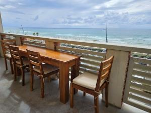 een tafel en stoelen op een balkon met uitzicht op het strand bij Résidence Pasino in Lacanau-Océan