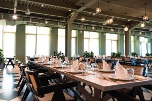 uma grande sala de jantar com uma mesa longa e cadeiras em Kronos Hotel em Durrës
