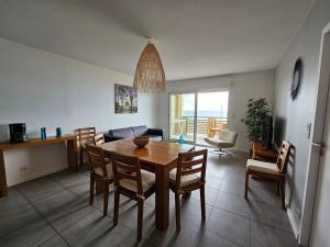 uma cozinha e sala de jantar com mesa e cadeiras em Résidence Pasino em Lacanau-Océan