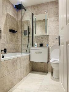 ein Badezimmer mit einer Badewanne, einem WC und einem Waschbecken in der Unterkunft One bedroom posh and neat flat in Thamesmead