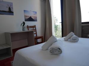 Un dormitorio con una cama blanca con toallas. en Al Vecchio Pontile bed and breakfast, en Marsala
