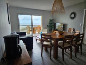 een woonkamer met een tafel en stoelen en een eetkamer bij Résidence Pasino in Lacanau-Océan