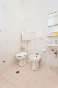 bagno bianco con servizi igienici e lavandino di Hotel Costaverde a Cesenatico