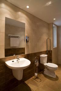 a bathroom with a sink and a toilet and a mirror at Hostal Doña Blanca in Sigüenza