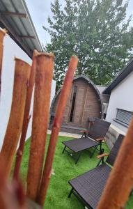 una valla con 2 sillas, una mesa y una cabaña en Schlaffass mit Wellness in alter Scheune, en Seinsheim