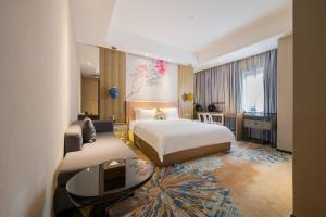 a hotel room with a bed and a desk at Paco Hotel Tаojin Metro Guangzhou-Free Shuttle Bus For Canton Fair in Guangzhou