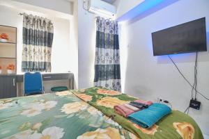 Un pat sau paturi într-o cameră la Room Rendi @ Apt Dramaga Tower
