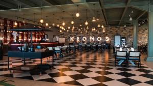a restaurant with chairs and a checkered floor at Kronos Hotel in Durrës