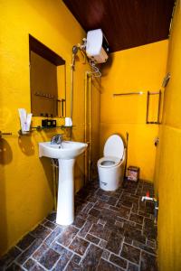 Baño amarillo con aseo y lavamanos en Đồng Văn Panorama Homestay en Dồng Văn