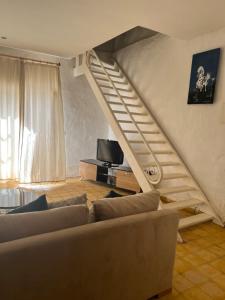 a living room with a couch and a staircase at Appart-hotel la lune du desert in Erfoud