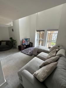 a living room with a couch and a tv at Suites by Rehoboth - Building XXII - Royal Arsenal in Woolwich