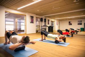 eine Gruppe von Leuten, die Yoga in einem Fitnessstudio machen in der Unterkunft ROBINSON ALPENROSE Zürs in Zürs am Arlberg