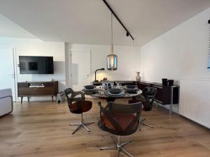 a living room with a dining table and chairs at Charmant appartement au look design in Mons