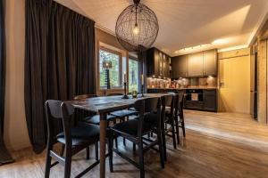 a kitchen with a dining room table and chairs at Vasabyn Fjällbacken - Lindvallen - Ski in Ski out in Sälen