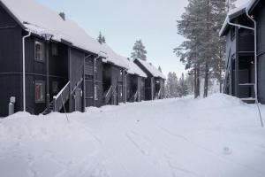 a snow covered street in front of a building at Vasabyn Fjällbacken - Lindvallen - Ski in Ski out in Sälen