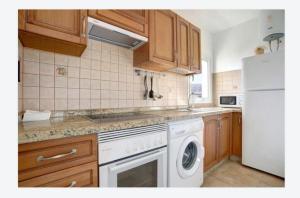 uma cozinha com um fogão branco e uma máquina de lavar louça em CASA AZUR em Arrieta