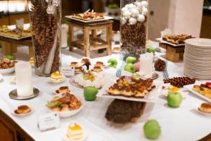 a table topped with plates of food and desserts at ROBINSON ALPENROSE Zürs in Zürs am Arlberg