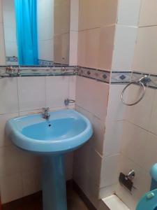 a bathroom with a blue sink and a mirror at New Kitisuru A in Nairobi