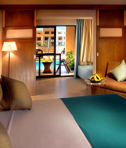 シャルム・エル・シェイクにあるCoral Sea Aqua Club Resortのベッド1台、ソファ、バルコニーが備わる客室です。