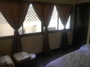 1 dormitorio con 1 cama y un par de ventanas en GUNG Apartment, en Pattaya South
