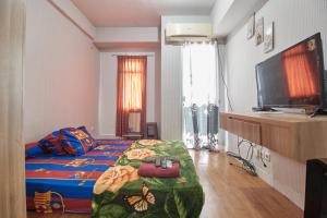 Un pat sau paturi într-o cameră la Room Rendi @ Apt Dramaga Tower