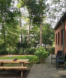 a wooden picnic table sitting next to a building at Van Horick in Baal