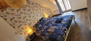 a large bed with a blue comforter and a wall at Gîte cozy proche du Zoo de Beauval / Châteaux de la Loire N1 in Selles-sur-Cher