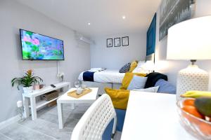a room with two beds and a living room at Cozy Studio retreat in Vibrant Crystal Palace, in Upper Norwood