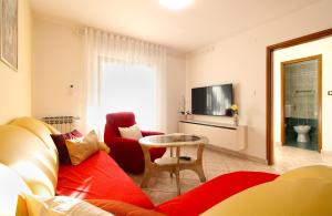 a living room with a couch and a table at Apartments Slavko 1179 in Banjole