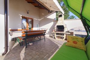 a porch of a house with a table and a stove at Apartments Slavko 1179 in Banjole