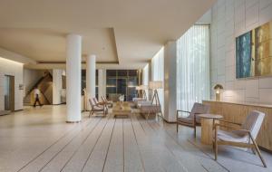 a lobby with chairs and tables in a building at 37th Crescent Hotel Bengaluru in Bangalore