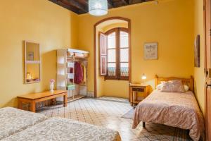 une chambre avec deux lits et une table et une fenêtre dans l'établissement Casa emblemática Buenavista del Norte, à Buenavista del Norte