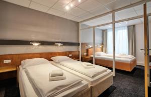 a hotel room with two beds and a mirror at Hotel & Apart4you in Dorfen