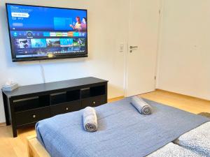a bedroom with a bed and a flat screen tv at Entspannte Souterrain Wohnung in Munster im Heidekreis