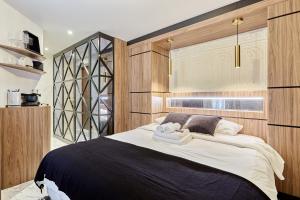 a bedroom with a large bed with wooden walls at Apart hotel Louvre museum by Studio prestige in Paris