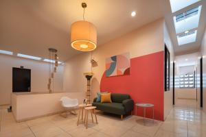 a living room with a green chair and a red wall at Cove Oekude Residence in Jakarta